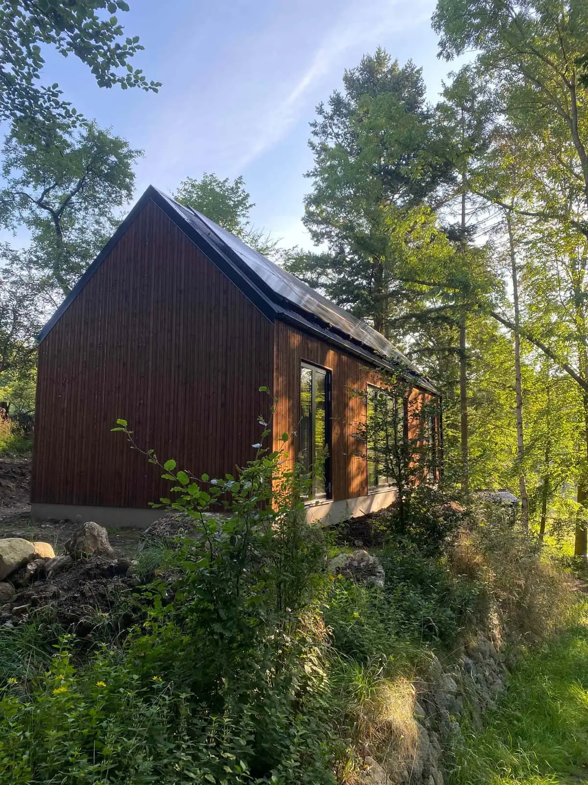Nyt hus i sortmalet træbeklædning mellem træer